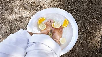 Belebendes basisches Fußbad mit Eiswürfeln und in Scheiben ges