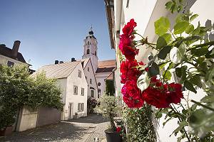 Rosen empfangendes gepflastertes Gässchen zur Frauenkirche in G