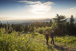Paar wandert auf dem Fichtelberg im Erzgebirge mit Bergpanorama