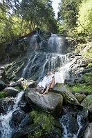 Paar im Bademantel entspannt sich am Wasserfall