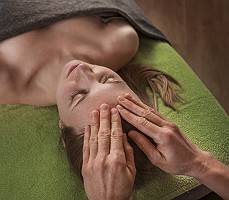 Entspannende Kopfmassage auf grünem Handtuch