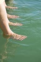 Zwei Personen hängen ihre Füße ins Wasser