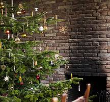 Schön geschmückter Weihnachtsbaum vor einer Backsteinwand mit