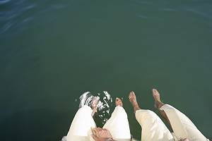 Zwei Personen lassen ihre Füße ins Wasser hängen
