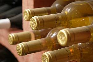 Liegende Weinflaschen eines Weißweins im Weinregal