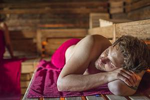 Mann auf Handtuch iliegend in der Sauna