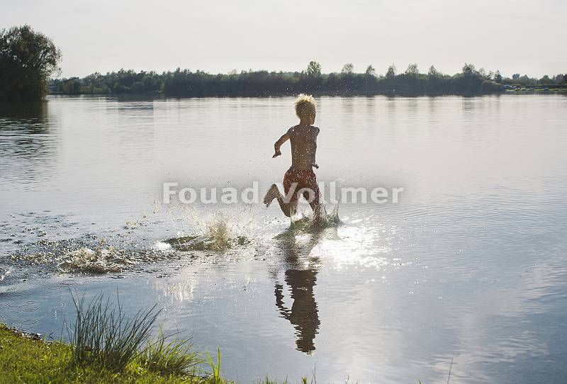 Kind rennt in Badehose in den See