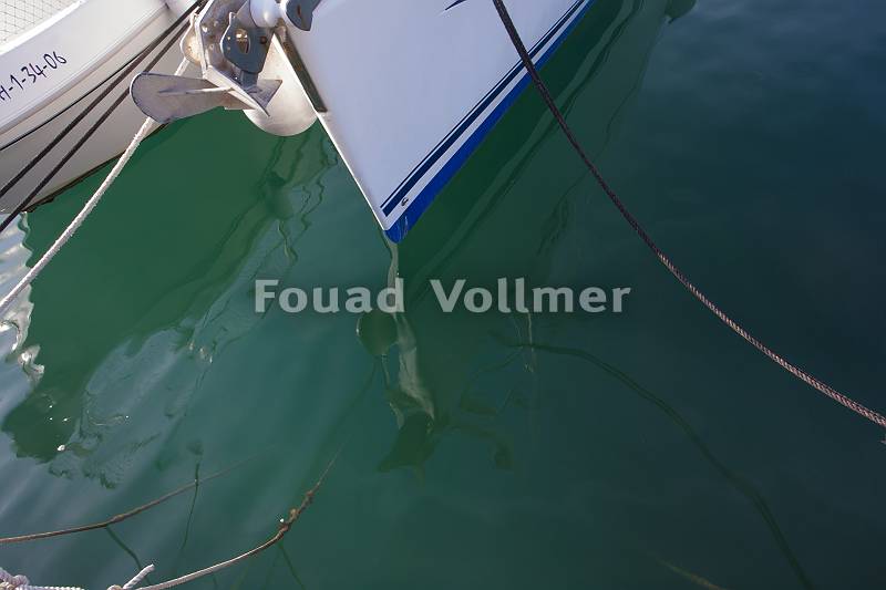 Fotografie von Wasser mit einer Spiegelung eines Bootes.