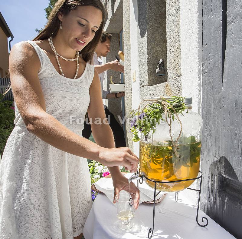 Frau im weißen Kleid zapft selbstgemachte Limonade