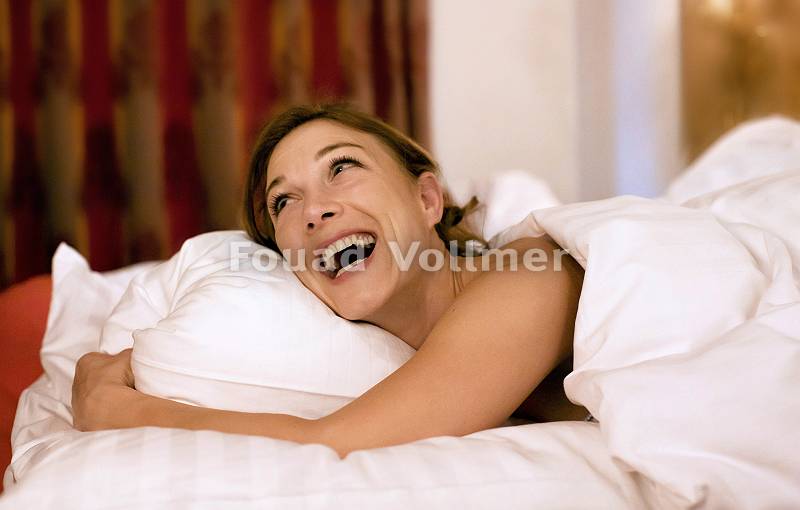 Frau erwacht glücklich aus dem erholsamen Schlaf