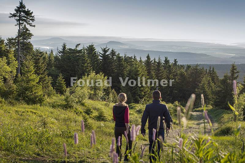 Paar wandert auf dem Fichtelberg im Erzgebirge mit Blick über d