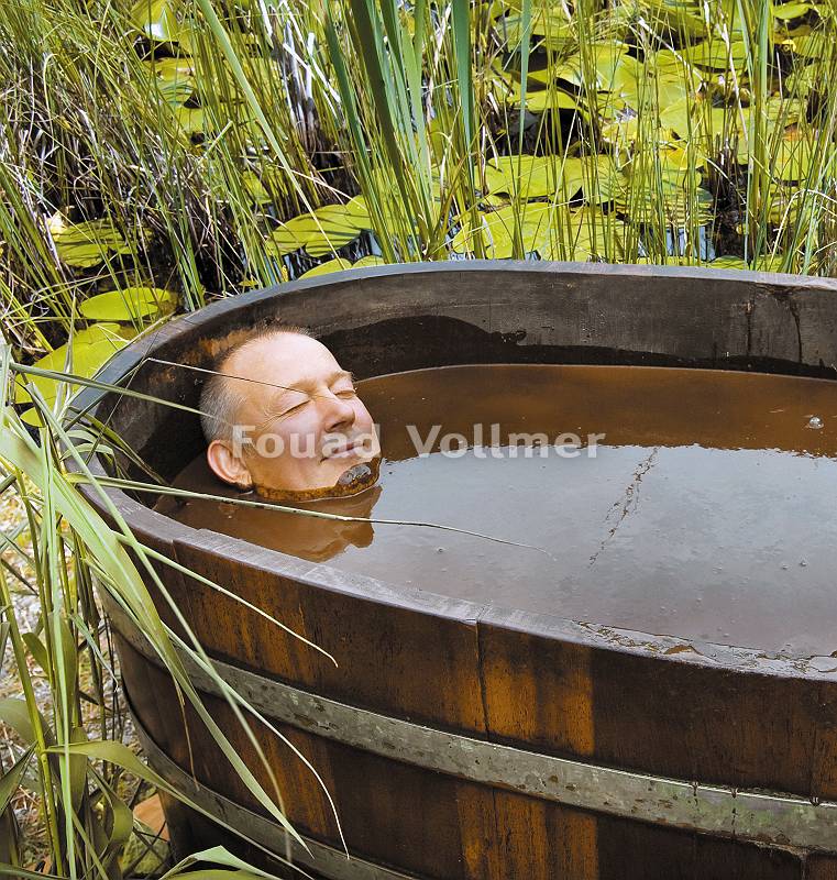 Mann genießt Moorbad dem natürlichen Heilmittel Moor, in einer