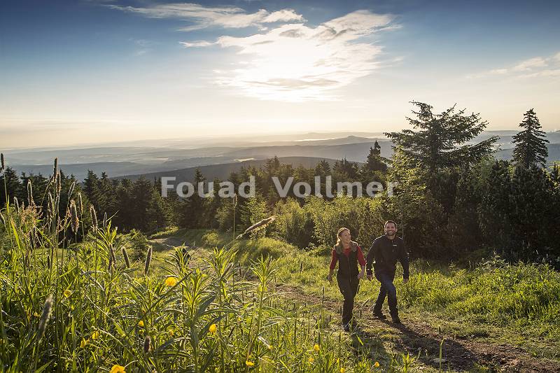 Paar wandert auf dem Fichtelberg im Erzgebirge mit Bergpanorama