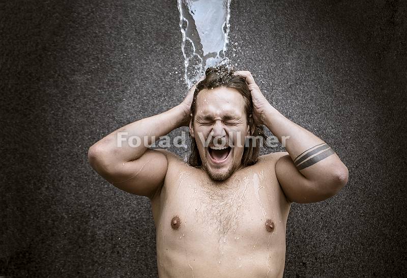 Kräftiger junger Mann schreiend beim Dusche