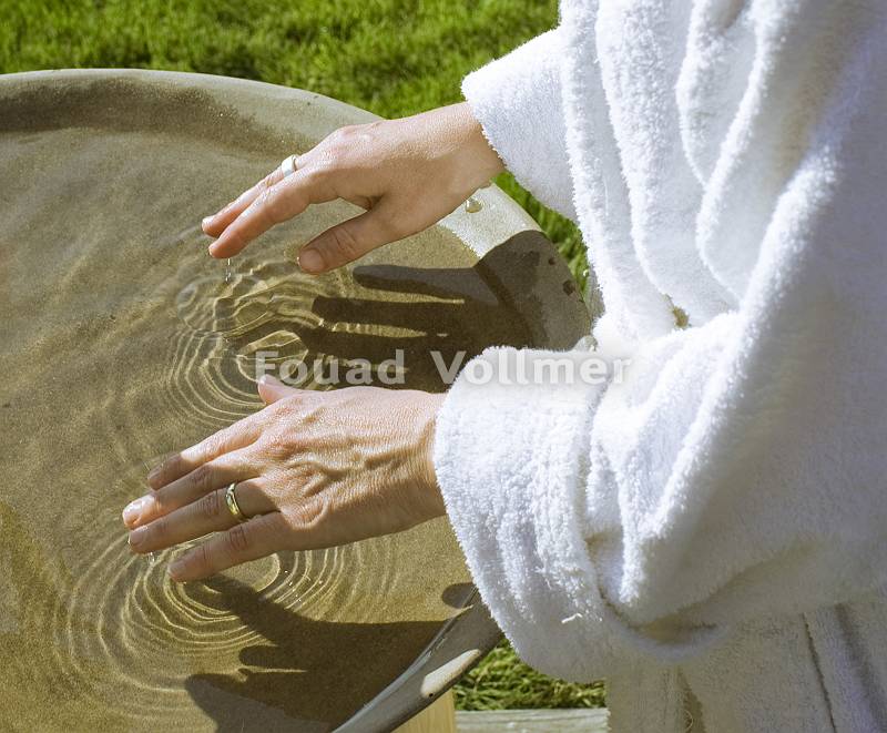 Frauenhände schwebend über einer Wasserschüssel