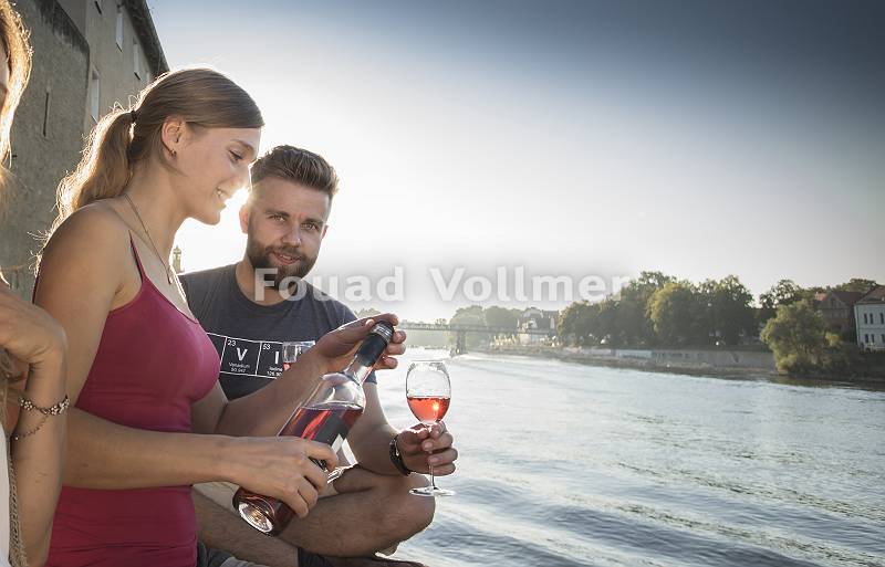 Paar genießt bei einem Glas Wein den Feierabend an der Donau in