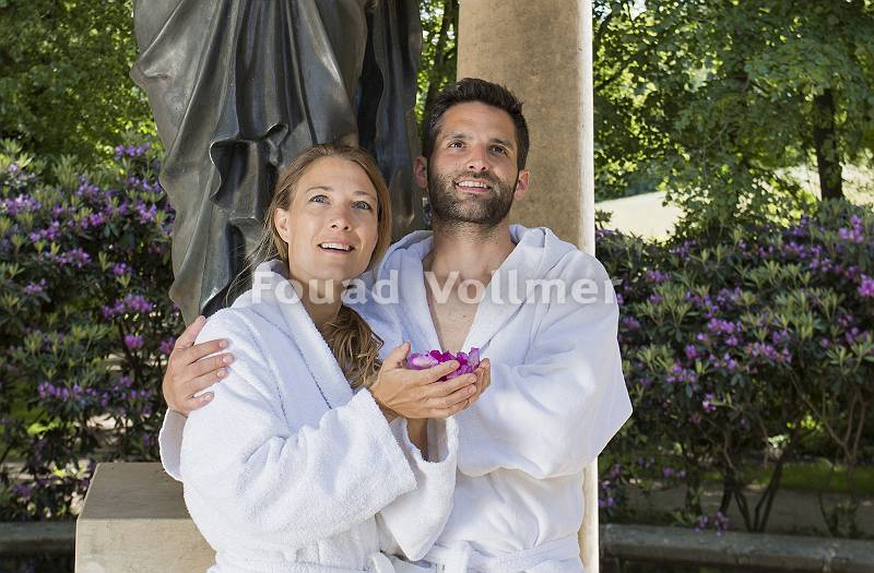 Paar im Bademantel steht vor antiker Statue
