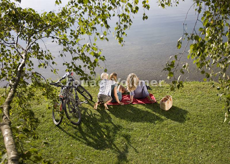 Freundinnen mit Sohn rastet nach Radtour am Seeufer