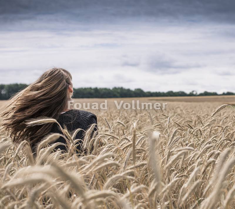 Junge Frau mit langem wehendem Haar genießt den Wind in einem G
