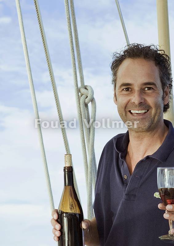 Mann mit Weinglas auf Boot